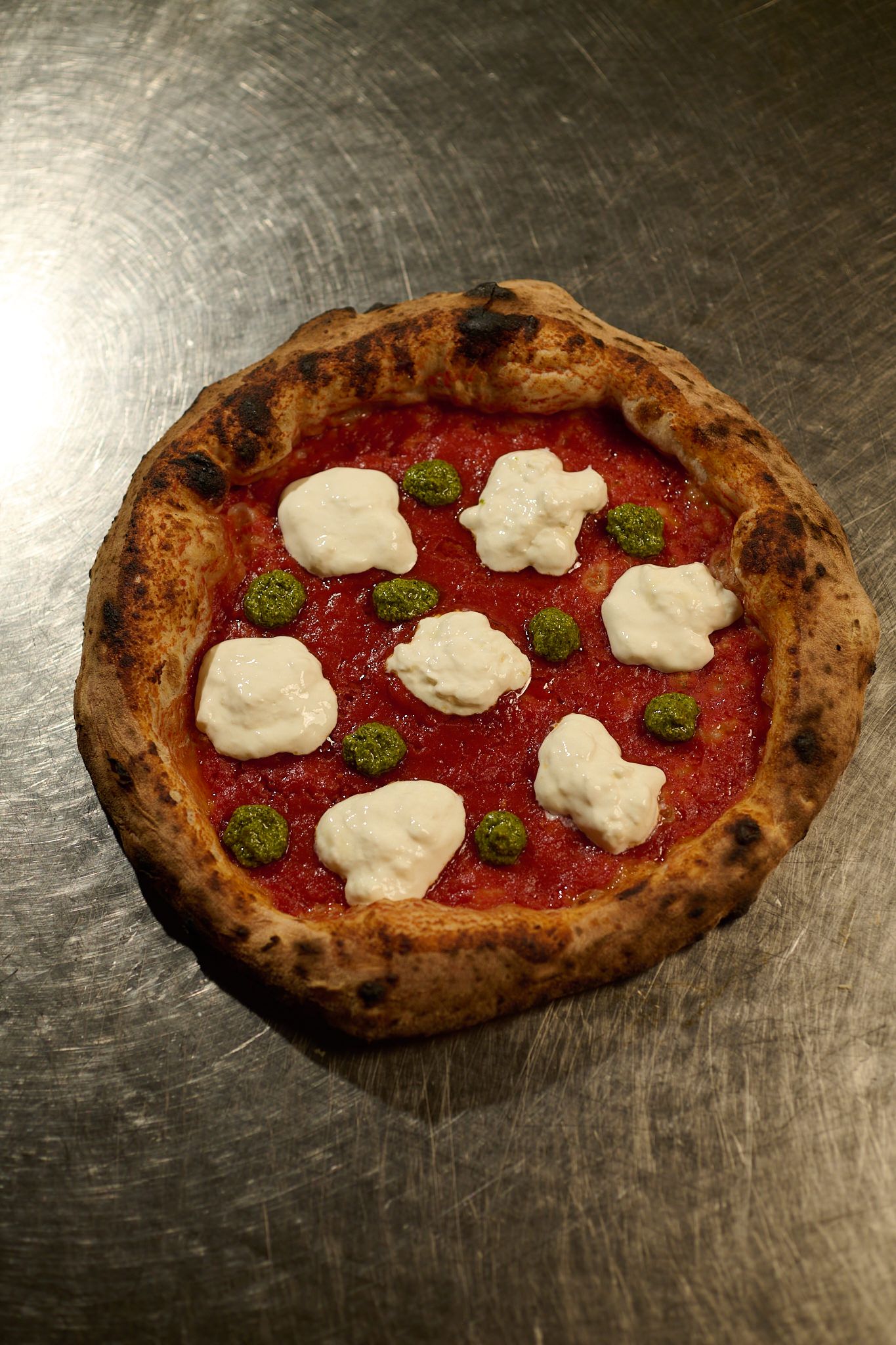 Pizza appena sfornata sul banco d’acciaio